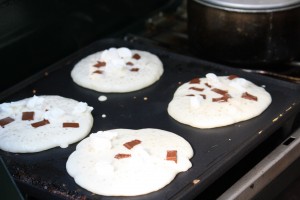 Pour pancake batter onto the griddle.  Sprinkle chocolate chips and mini marshmallows onto pancakes.