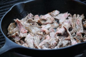 Sliced ribeye steak in a cast iron skillet